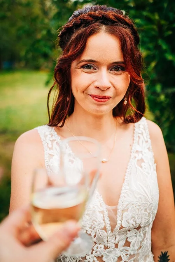 Une mariée qui trinque avec une coupe de champagne à son mariage