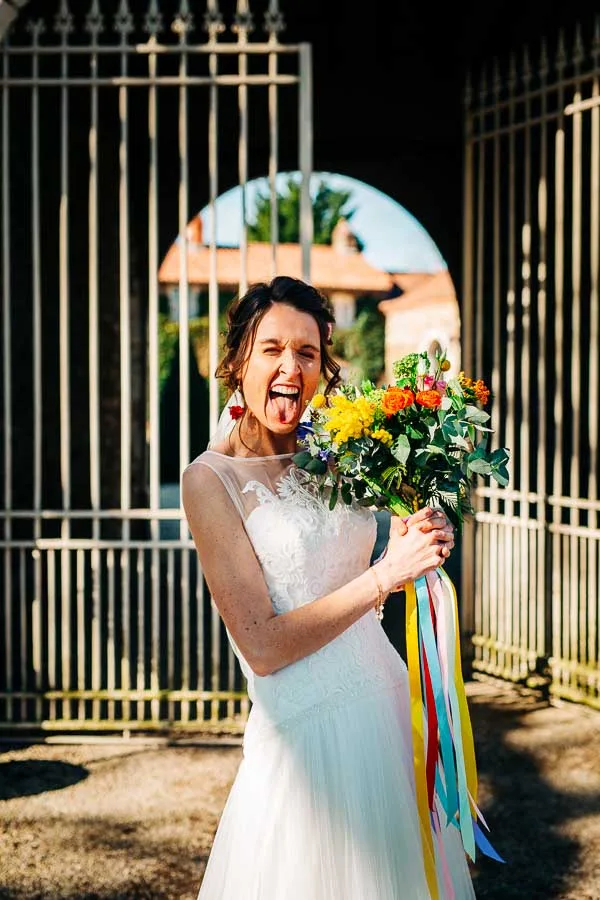 Une mariée qui tire la langue devant la grille de la seigneurie du bois Benoist