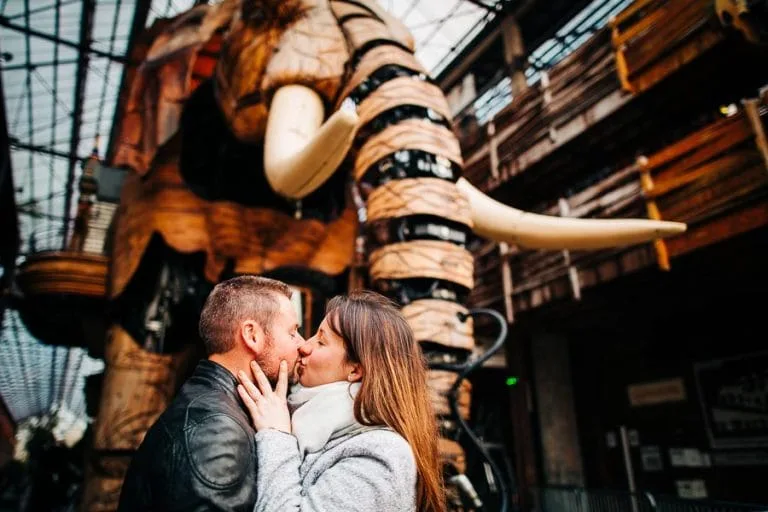 Un couple en séance lifestyle qui s'embrasse devant l'éléphant de Nantes