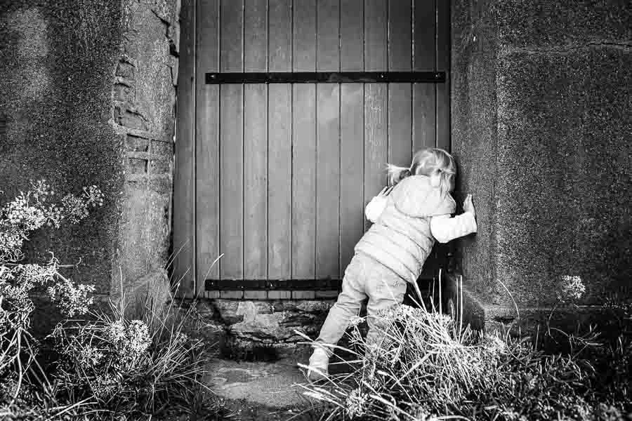 Jeune fille regardant derrière une porte