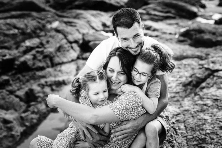 Une famille qui se fait des câlins sur les rochers